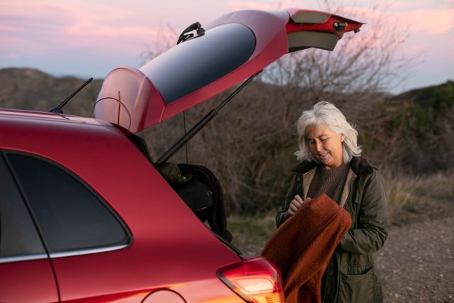 older woman out nature adventure with her car