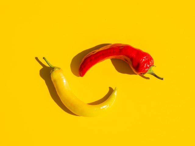 flat lay arrangement with spicy peppers yellow background