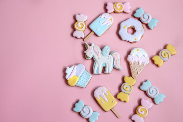 flat lay composition with bright glazed gingerbread cookies pink background