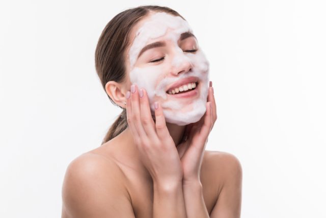 beautiful woman with facial mask white wall cosmetics skin care