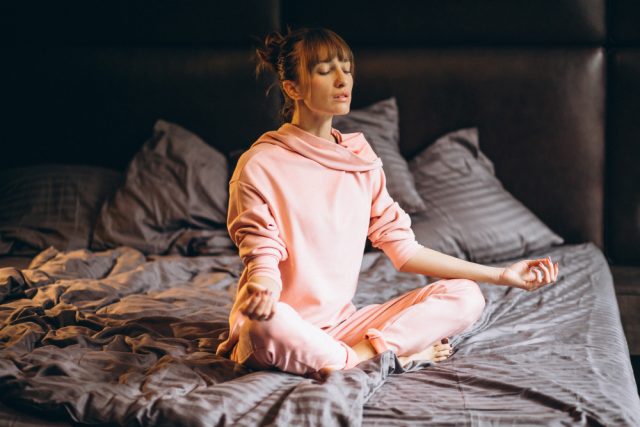 woman doing yoga bed